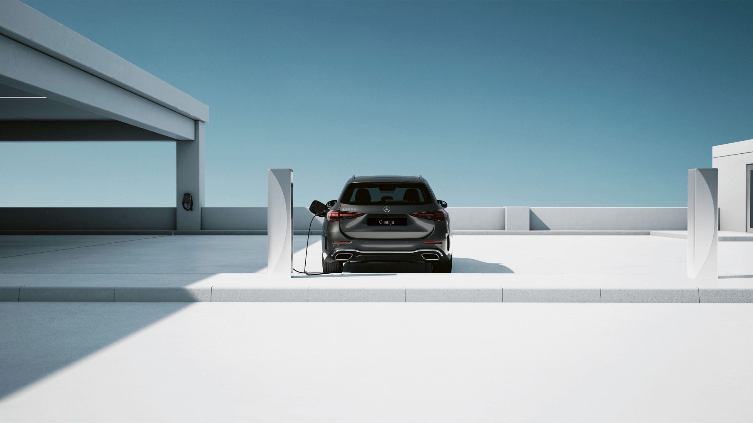 Mercedes-Benz C-klassi sõiduauto laadimine valge hoone kõrval.